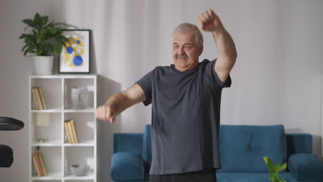 funny-man-with-moustache-is-doing-physical-exercise-at-morning-at-home-lifting-and-lowering-hands-medium-portrait-indoors